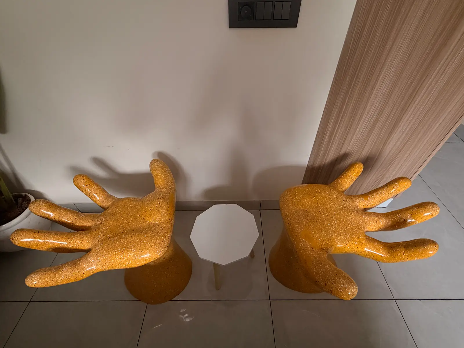 Pair of yellow hand-shaped chairs and a small table in the living corner