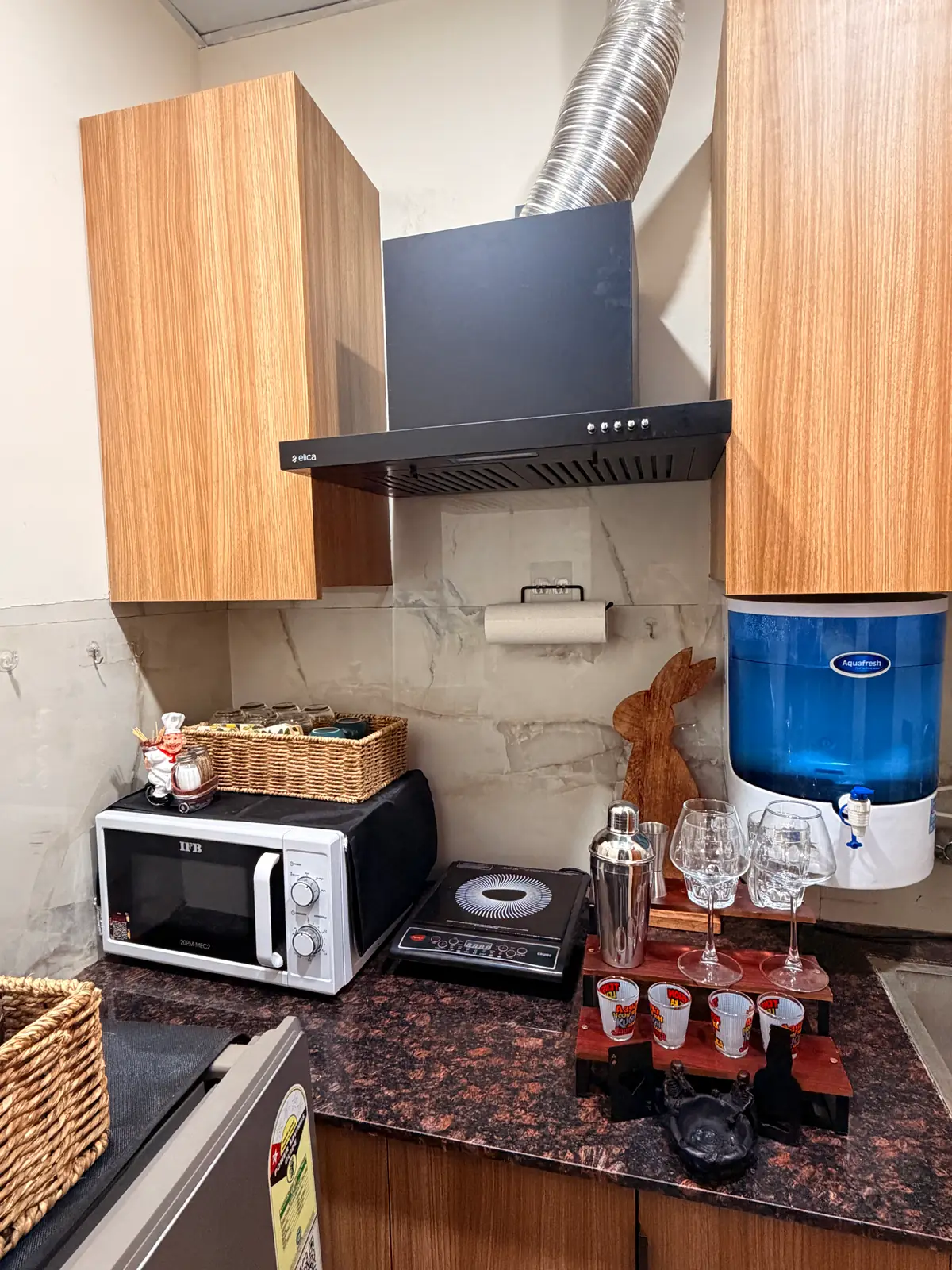 Fully equipped kitchenette with induction cooktop, microwave and barware